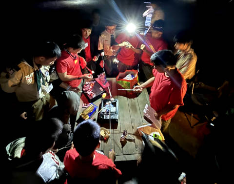 Scouts around a burner burning something