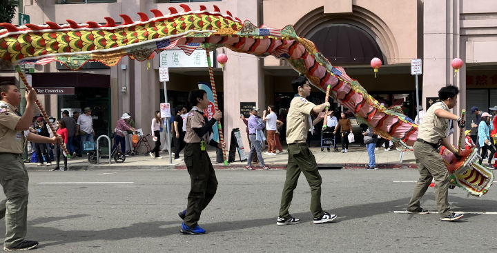 Scouts rotate a dragon as they walk forward