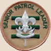 Senior patrol leader badge: three horizontal green lines with a silver scouting symbol on top and the words senior patrol leader curved near the edge of the top semicircle